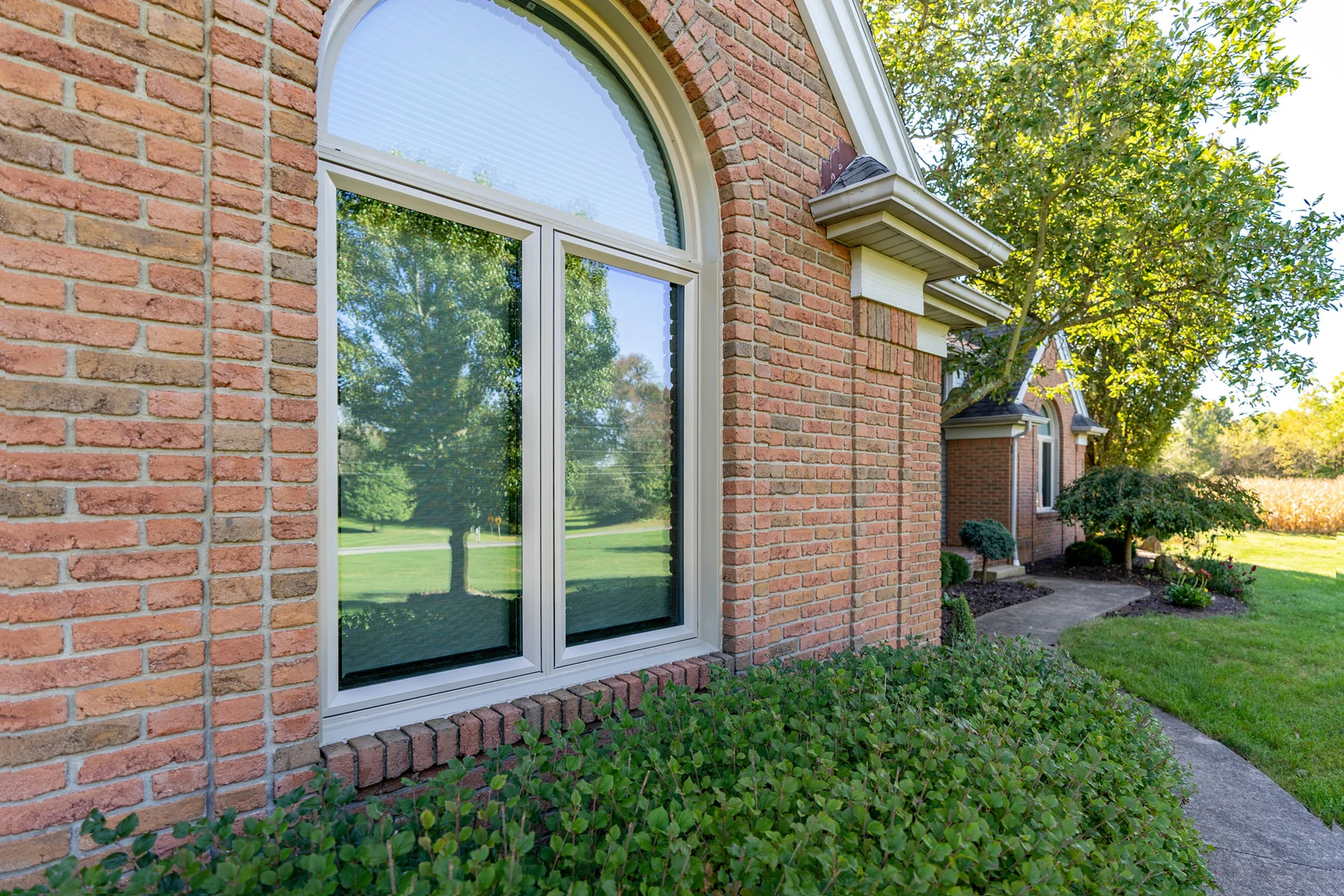 ProVia Aeris sandstone shaped windows on a brick home